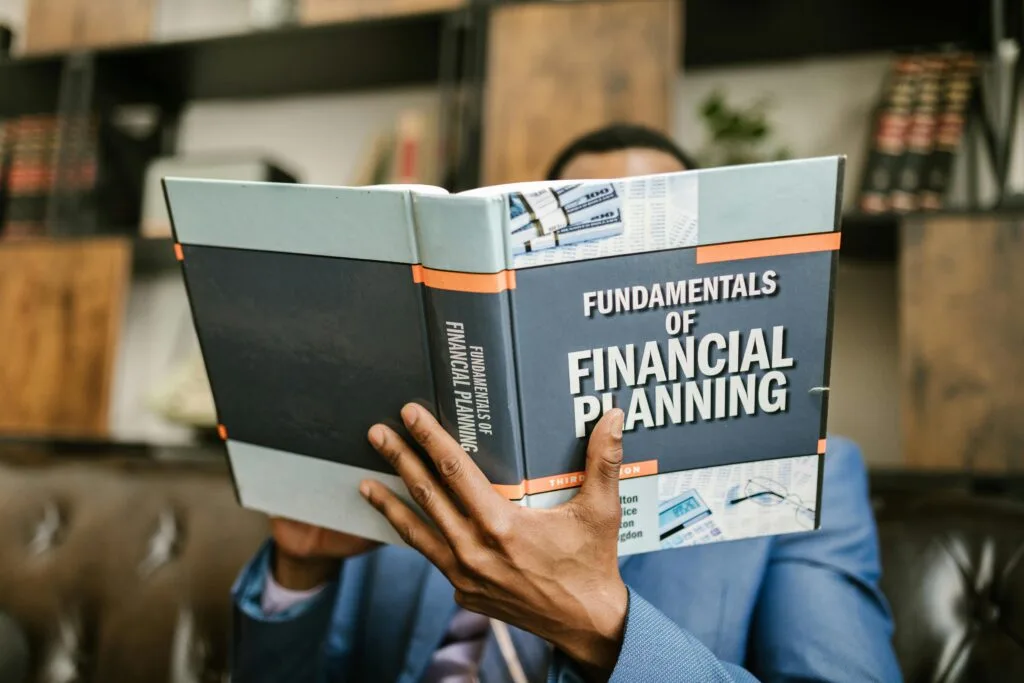pexels-photo-7821487-7821487 Person Reading a Book About Fundamentals of Financial Planning